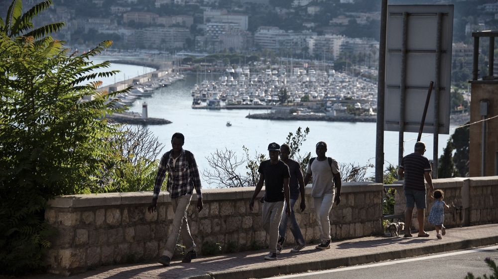 Sudanese refugees deported back over the Italian border at Menton by French police walk back to Ventimiglia 8km away [Maurizio Martorana/Al Jazeera]