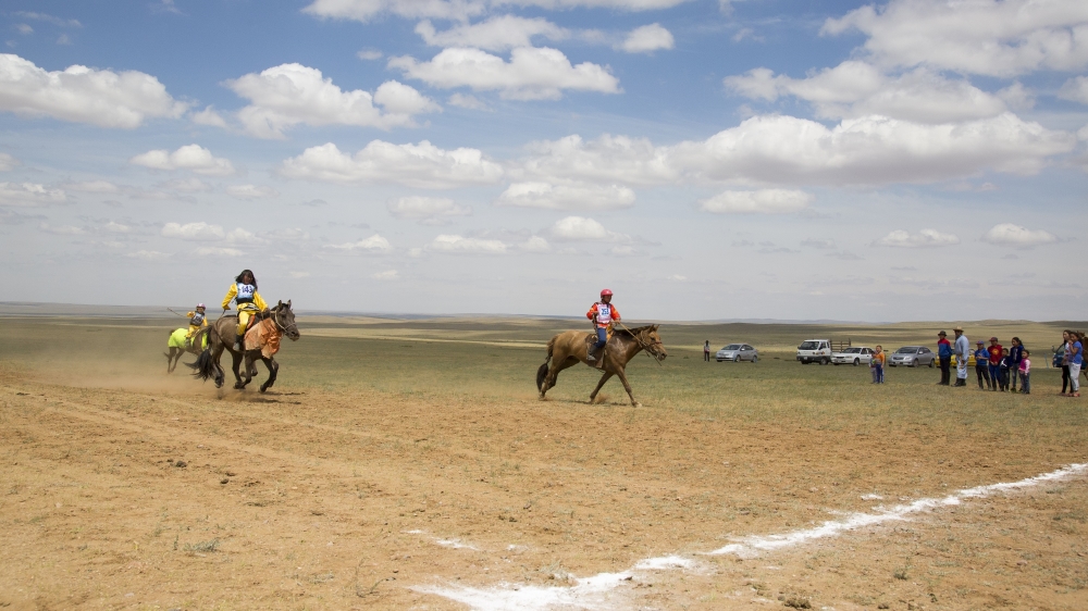 Bujinlkham Damdinsuren approaches the finish line at the end of the 24km horse race [Hannah Griffin/Al Jazeera]