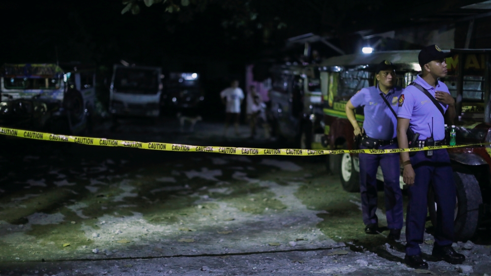 Policemen stand behind a police line after a man was killed during a police anti-drug operation in Caloocan city, Metro Manila