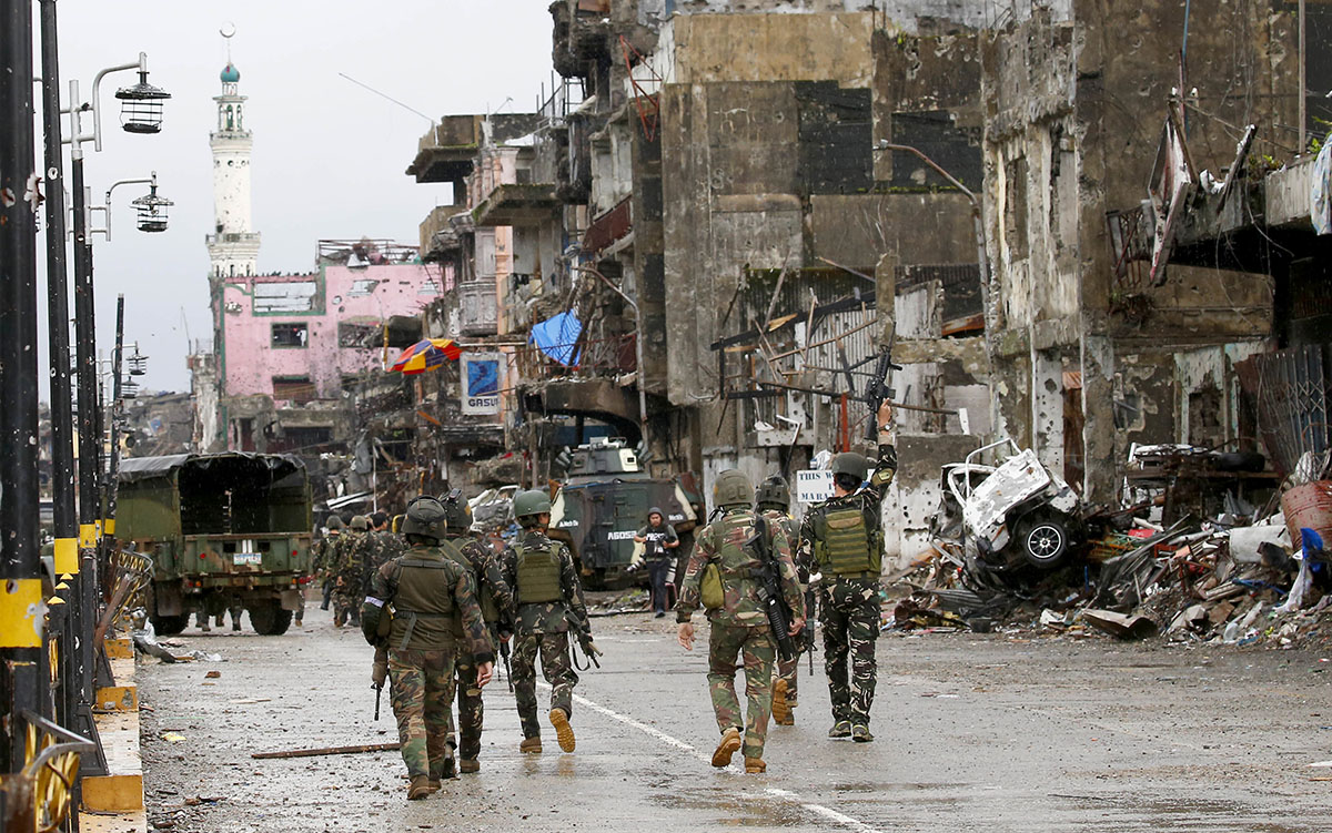 Amidst the ruins at "Ground Zero" Philippine troops return to their deployment after attending the ceremony wherein President Rodrigo Duterte declared the liberation of Marawi city in southern Philipp