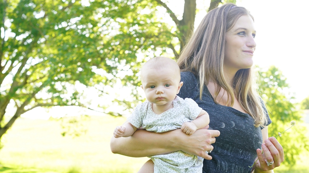 Recovering addict Amanda with her youngest child in the backyard of her Ohio home. [Josh Rushing/Al Jazeera]