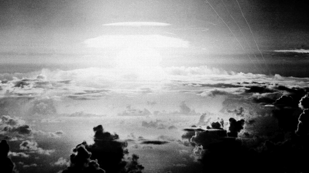 FILE - In this May 21, 1956, file photo, the fireball of a hydrogen bomb lights the Pacific sky a few seconds after the bomb was released over Bikini Atoll. Streamers at right are trails of rockets fi