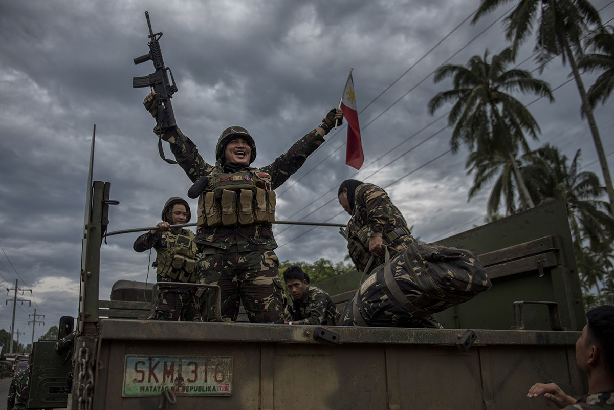 A government soldier waving the Philippine flag as they get ready to leave the battle against IS-inspired militants on October 20, 2017 in Saguiaran town in Lanao del Sur, southern Philippines. Presid