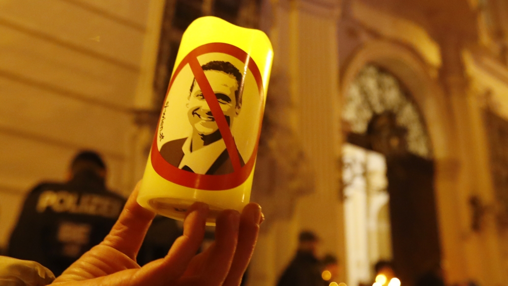 A demonstrator holds a candle with a picture of FPOe head Strache in a protest demanding no government participation for the far right in Vienna