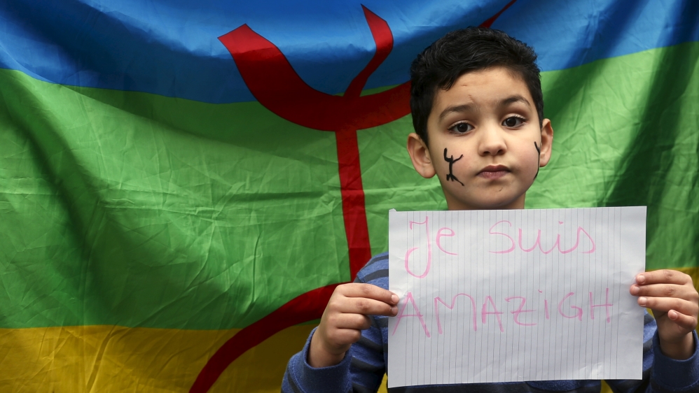 Boy holds a placard in front of an Amazigh flag during a demonstration in front of the Brussels'' office of Flemish right-wing party N-VA