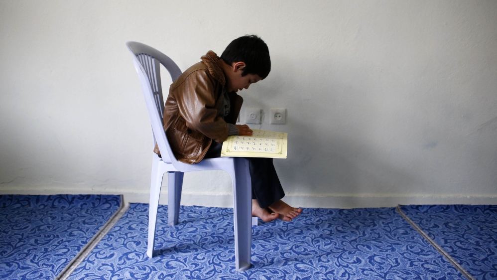 An Uighur refugee boy reads the Koran where he is housed in a gated complex in the central city of Kayseri, Turkey