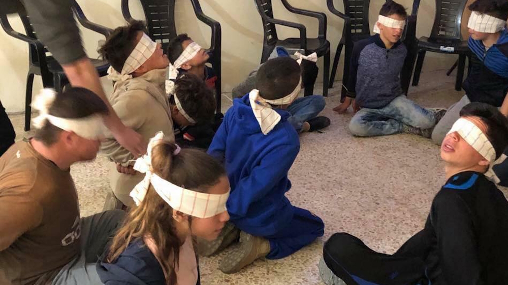 Palestinian children simulate a detention and interrogation by Israeli forces [Courtesy Manal Tamimi]