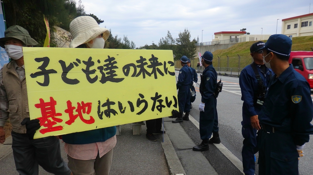 A protester holds a sign that reads, 