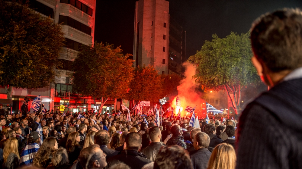 Supporters of re-elected president waved Cypriot and Greek flags [Dimitris Sideridis/Al Jazeera]