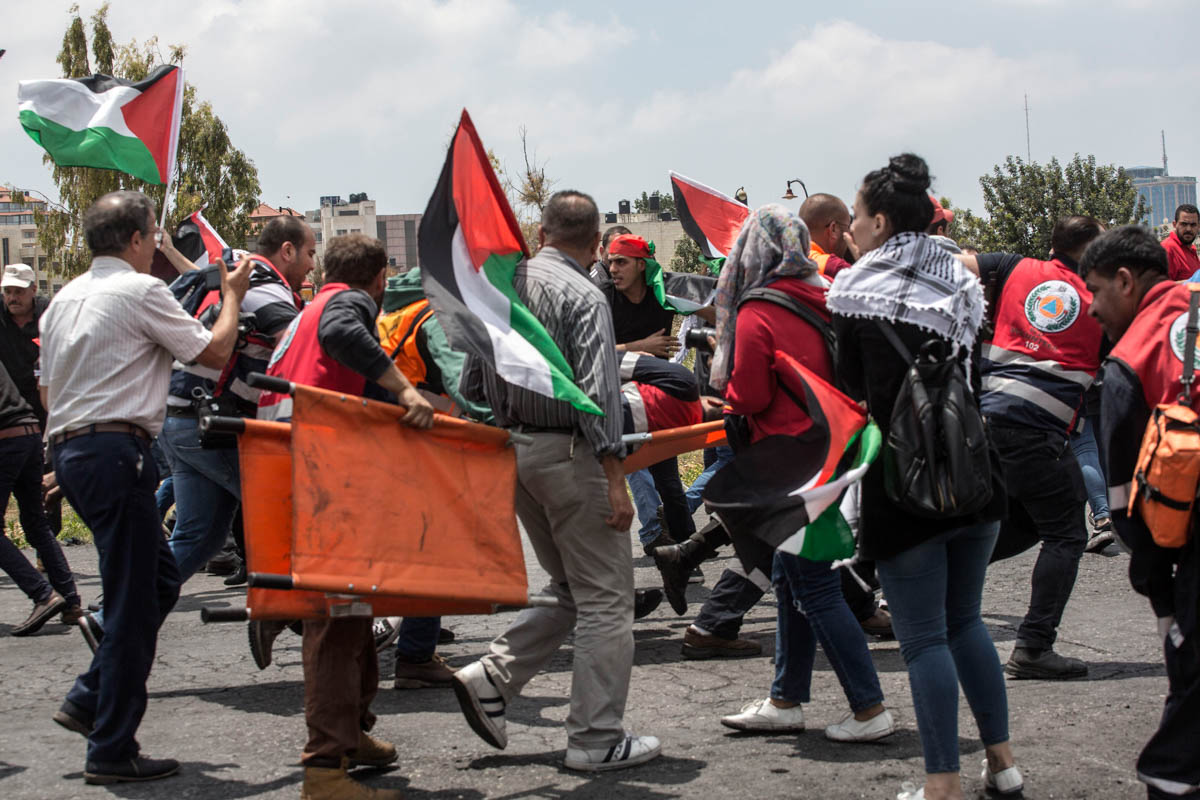 Palestinians carry a medic injured by Israeli forces during the clashes.