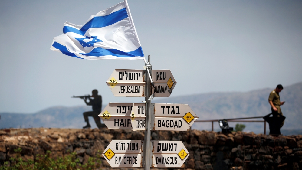 An Israeli soldier stands next to signs showing distances to different cities, on Mount Bental, an observation post in the Israeli-occupied Golan Heights overlooking the Syrian side of the Quneitra crossing [File: Reuters]