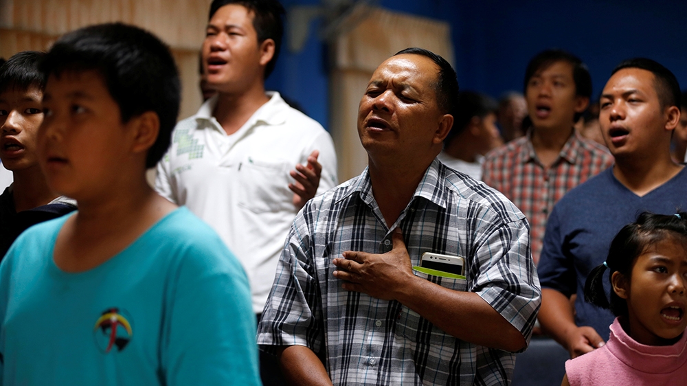 
Relatives and friends pray for the boys and their soccer coach tapped inside a flooded cave, at Mesai Grace Church in the northern province of Chiang Rai [Soe Zeya Tun/Reuters]
