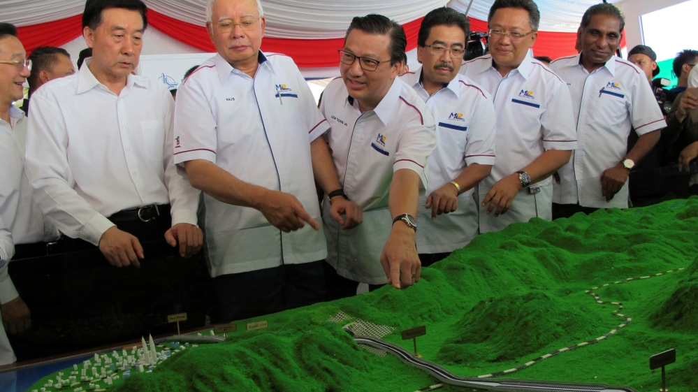 Malaysia''s Prime Minister Najib Razak and Transport Minister Liow Tiong Lai look at a model of the East Coast Rail Line at Kuantan Bahang