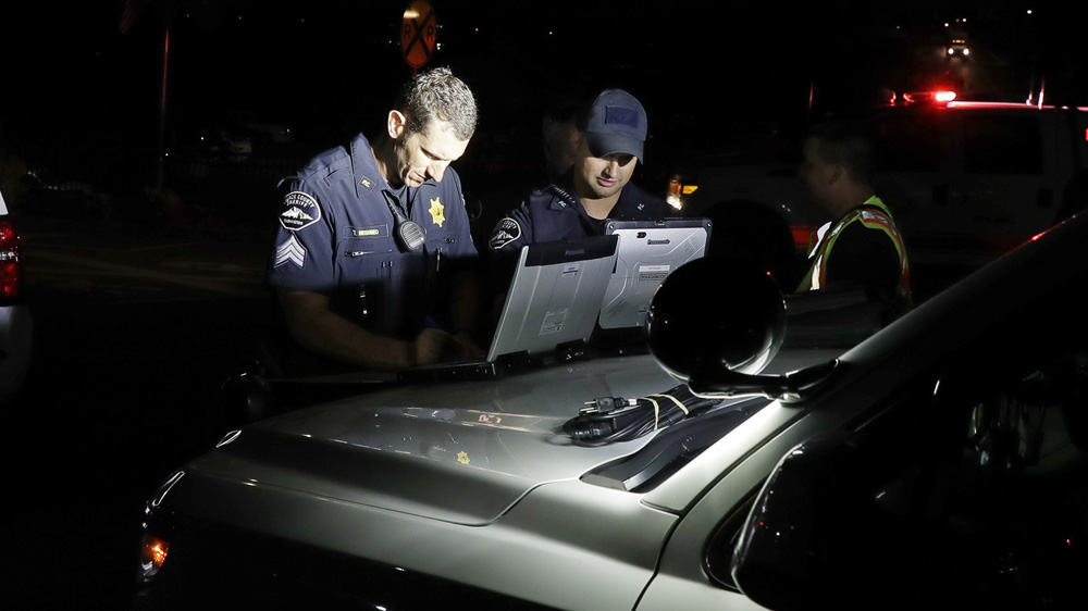 Law enforcement officials work at a staging area investigating the plane crash  [Ted S Warren/AP]