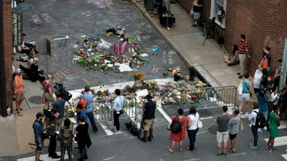 Mourners and passersby surround an impromptu memorial commemorating the victims of the car attack on a group of counterprotesters during the 2017 “Unite the Right” rally in Charlottesville