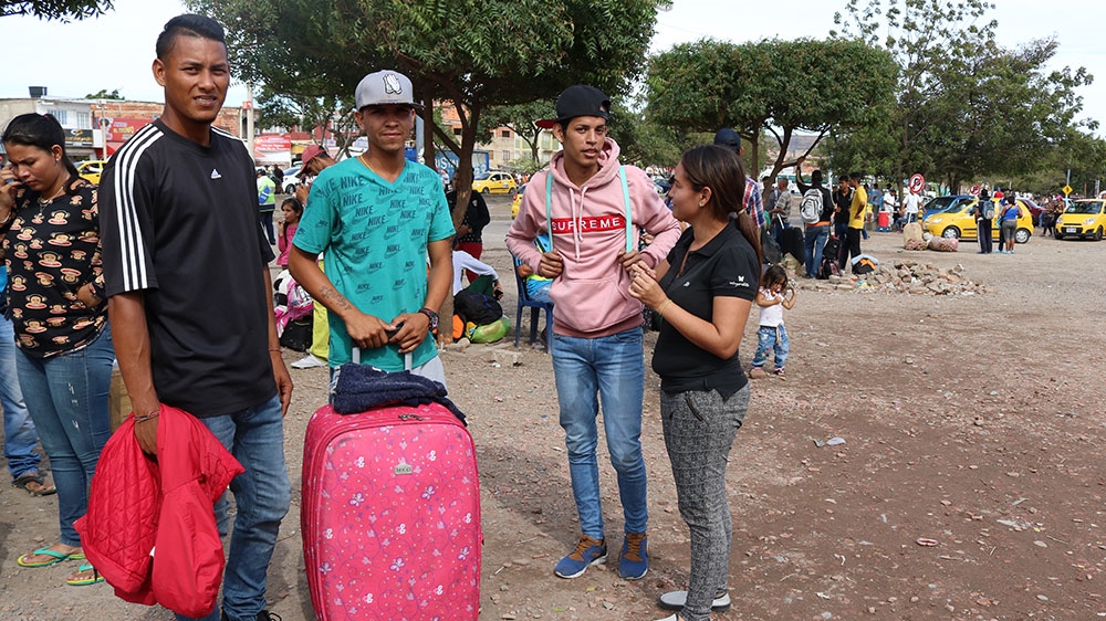 Suarez stands with his suitcase at the Venezuela-Colombia border [Dylan Baddour/Al Jazeera]