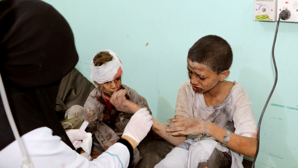 A doctor treats children injured by an airstrike in Saada