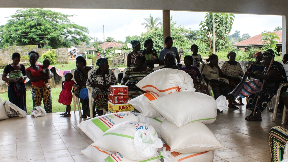 Cameroonian refugees gather at an aid centre in Agbokim Waterfalls village to collect food and other items [Linus Unah/Al Jazeera]