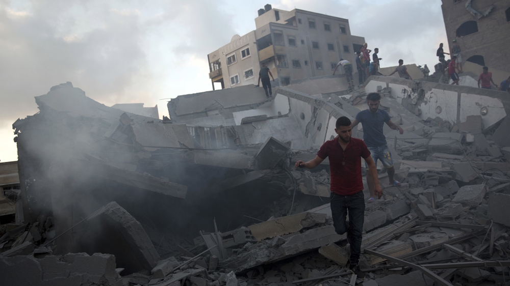 Palestinians inspect the damage after an Israeli air attack in Gaza City (AP Photo/Khalil Hamra)