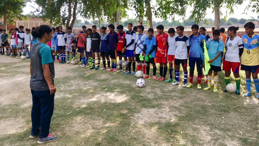 Coach Sonika Bijaria picks the girls' team who will face the local boys' team [Adnan Bhat/Al Jazeera]