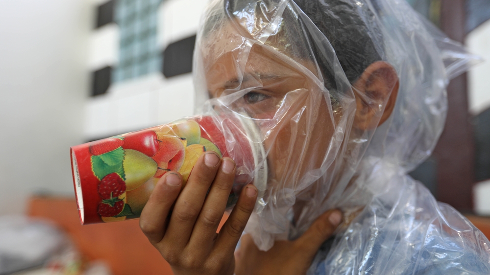 A Syrian child tries an improvised gas mask made by his father as part of preparations for any upcoming raids in the rebel-held Idlib province's village of Maar Shurin, on September 11, 2018 [Omar Haj Kadour/AFP]