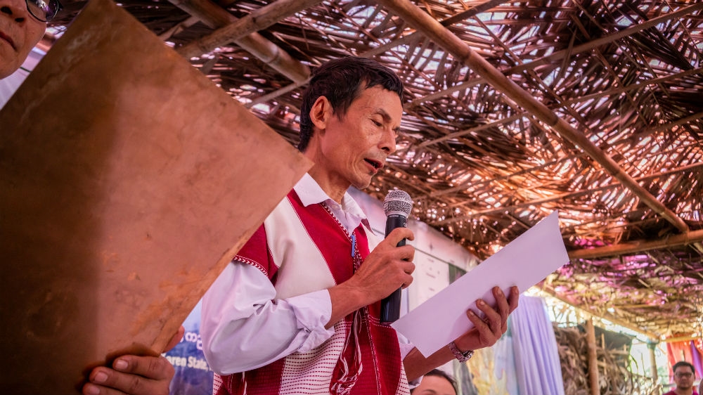 Karen civil society and political leaders read out and sign the Peace Park Charter in Mutraw District [Matias Bercovich/Al Jazeera]