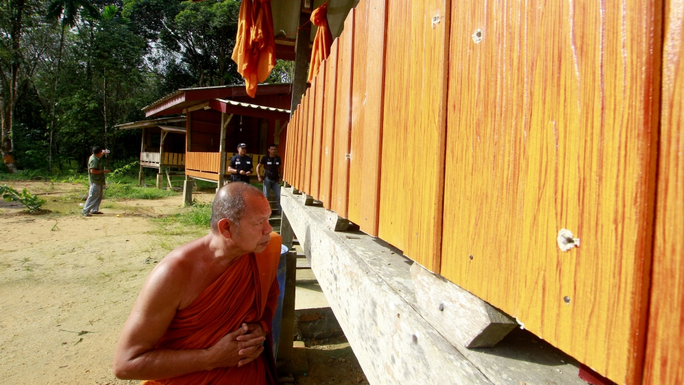 A monk looks at bullet holes on the site of Friday's attack [Surapan Boonthanom/Reuters]