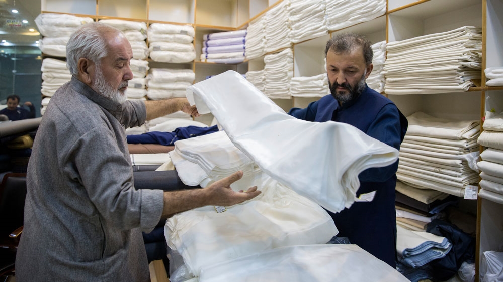 Abdul Raheem, right, a silk trader, is one of around 2,000 Uighurs in Pakistan [Saiyna Bashir/Al Jazeera]