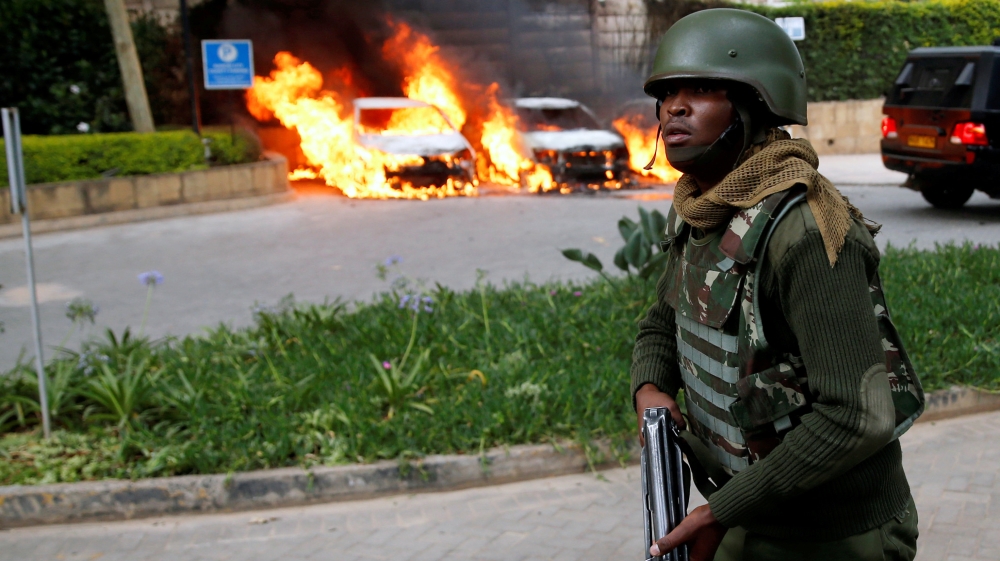 A policeman runs past burning cars at the scene of the attack [Baz Ratner/Reuters]
