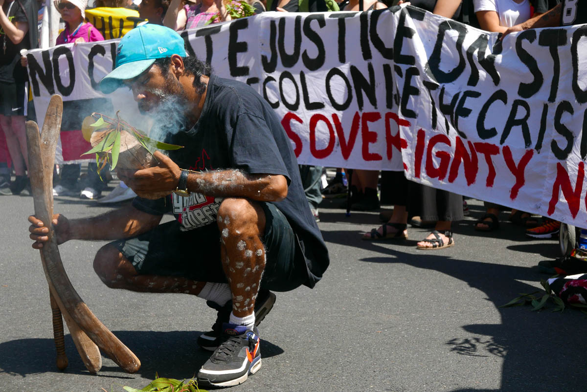 A man lights a continuous smoking ceremony made from eucalyptus leaves, used as part of healing for Aboriginal people.