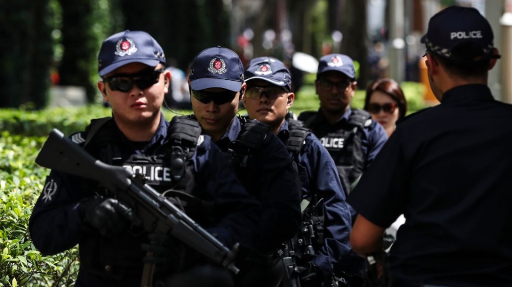 Police officers patrol outside the St Regis Hotel, where Kim stayed [File: Yong Teck Lim/AP Photo]