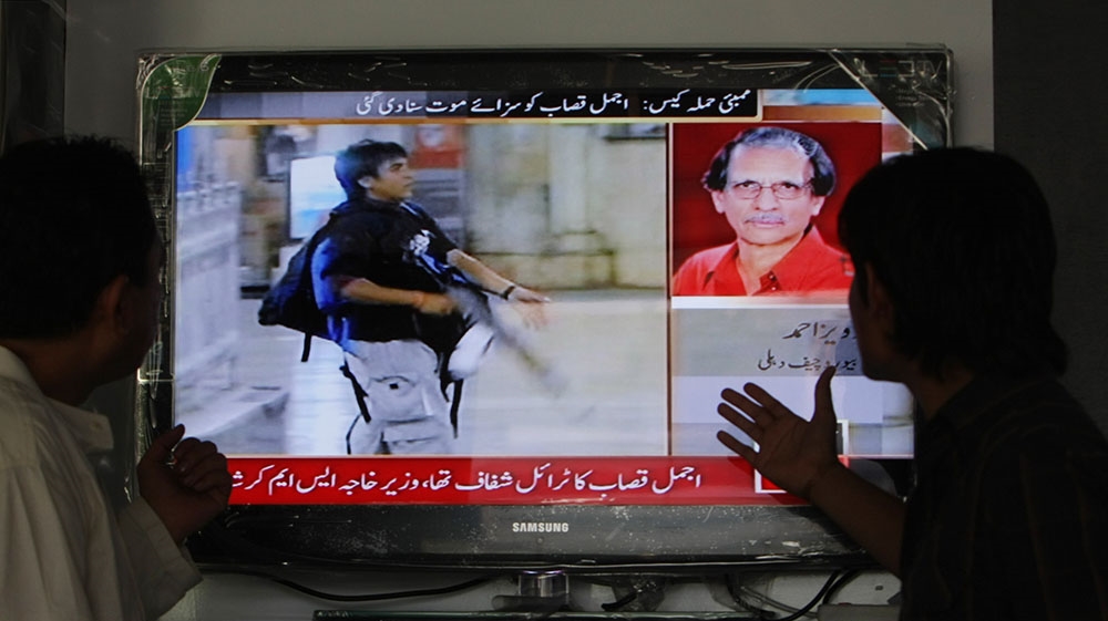 People watch television shows a news report about Mumbai attacks suspect Mohammed Ajmal Kasab in Karachi, Pakistan on May 6, 2010. [Fareed Khan/The Associated Press]