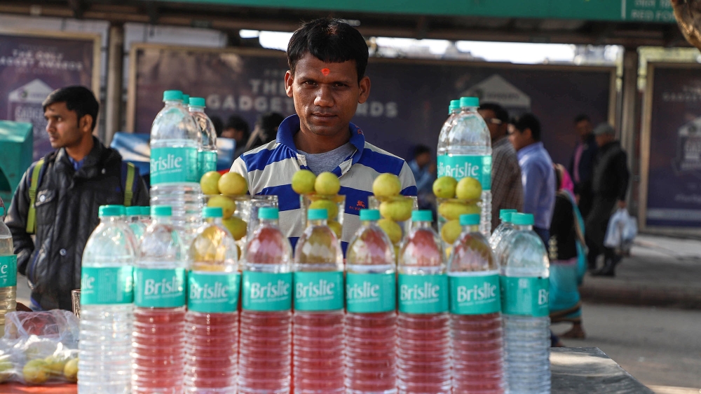 A vendor selling water bottles awaits customers in the old quarters of New Delhi, India. [Nasir Kachroo/NurPhoto/Getty Images]