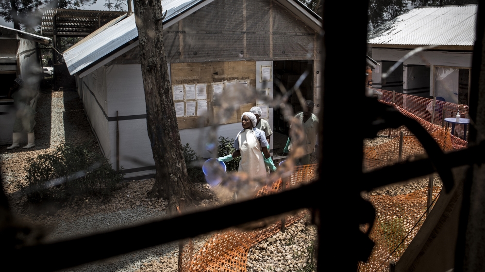 Health workers are seen through a bullet hole left in the window of an Ebola treatment centre, which was attacked in the early hours of the morning on March 9, 2019 in Butembo