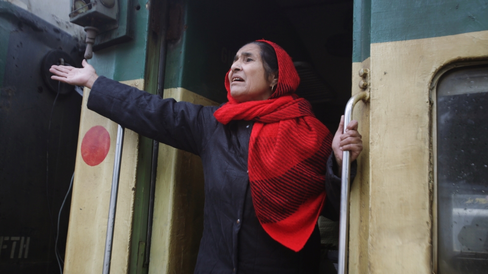 A passenger from India gestures to her relatives as she leaves by Samjhauta Express train [Mohsin Raza/Reuters]