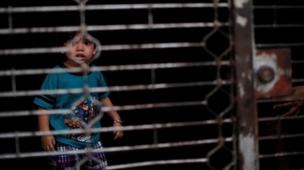 A child is seen inside a closed shop during the second day of a blackout in Caracas [Carlos Jasso/Reuters]