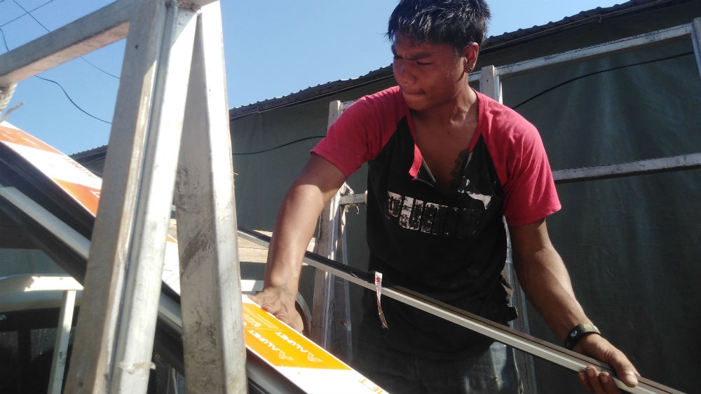 Sarayut Chumchai, a 22-year-old glass and mirror technician, went through the lottery for military service in 2018 and was relieved to draw a black card that exempted him. [Caleb Quinley/Al Jazeera]