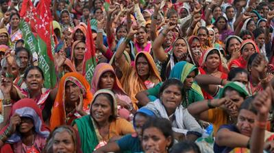 Farmers wave flags and shout slogans during a protest rally demanding loan waivers and the transfer of forest lands to villagers who have farmed there for decades, in Mumbai