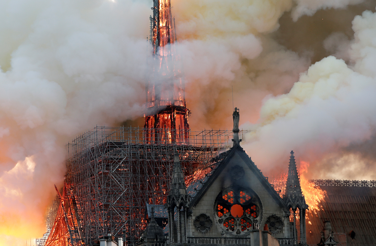 Smoke billows as the fire engulfs the spire of Notre Dame Cathedral in Paris [Benoit Tessier/Reuters]