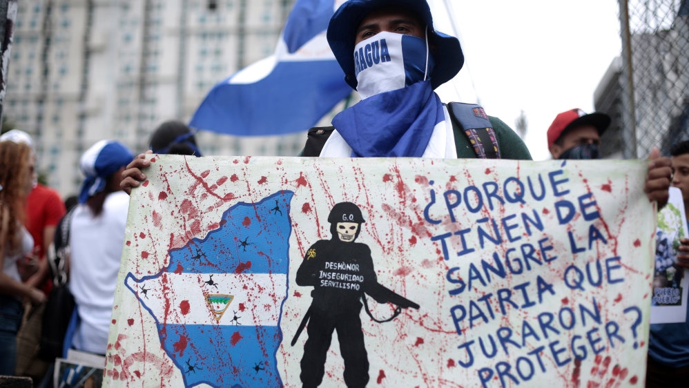 A Nicaraguan living in Costa Rica displays a banner saying 