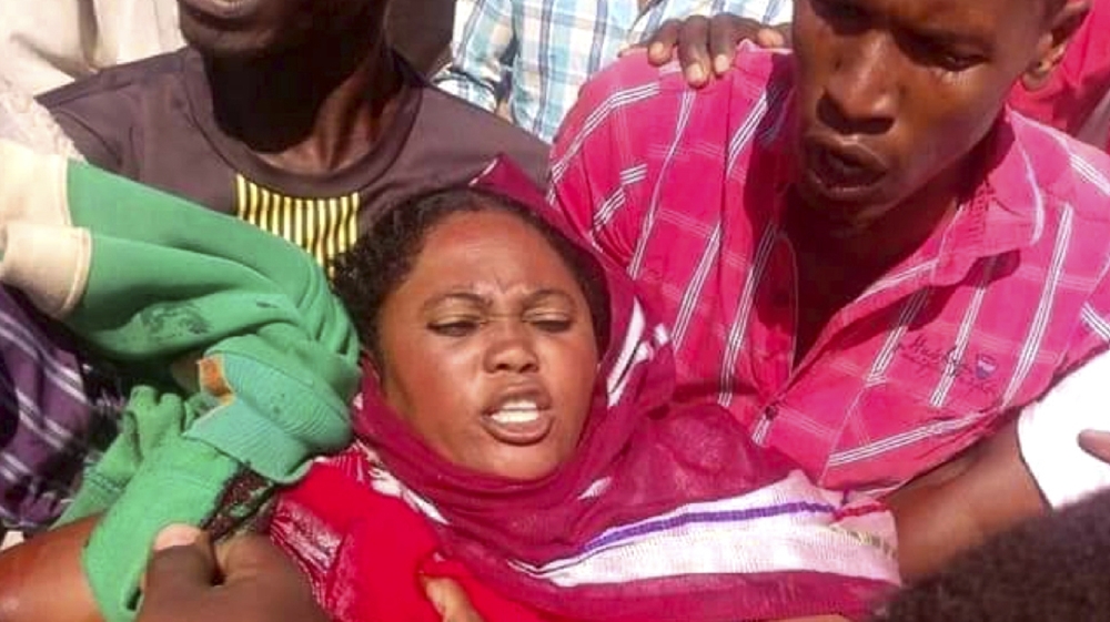 Demonstrators help a woman who was shot in her hand during clashes with security forces, in Umm Ruwaba, North Kordofan, Sudan on December 23, 2018 [Sudanese Activist via AP]