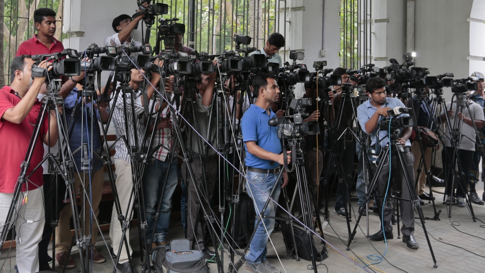 In this May 3, 2016 file photo, Bangladeshi journalists cover proceedings outside a court in Dhaka, Bangladesh. An influential body of newspaper editors in Bangladesh has criticized the government for