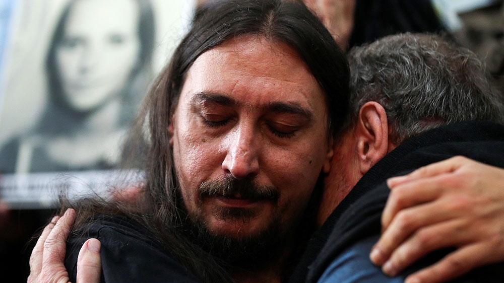 Javier Matias Darroux Mijalchuk, son of Elena Mijalchuk and Juan Manuel Darroux, who disappeared during Argentina’s former 1976-1983 dictatorship, is comforted by his uncle, Roberto Mijalchuk