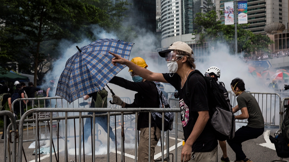 Protesters wearing masks reacts after police fired tear gas during demonstrations outside the Legislative Council Complex in Hong Kong on June 12, 2019. - Violent clashes broke out in Hong Kong on Jun