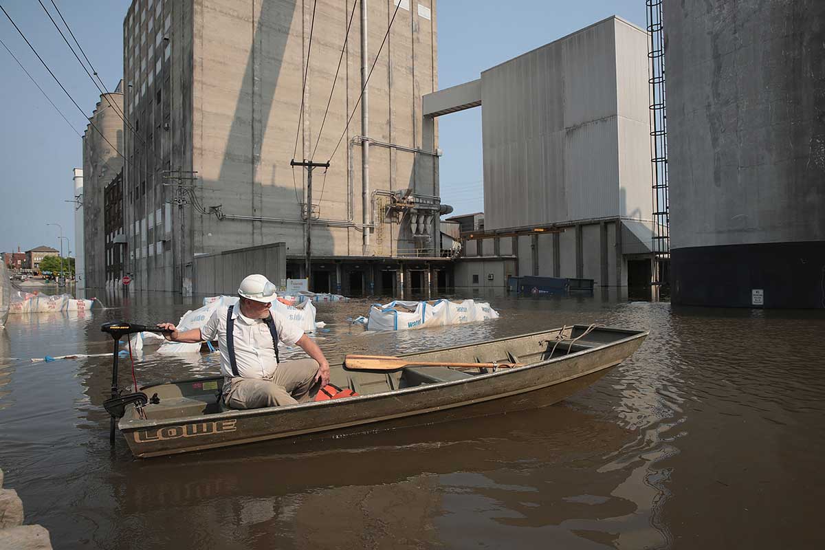 A worker ferries supplies through floodwater from the Mississippi River across Highway 100 to Ardent Mills in Alton, Illinois.