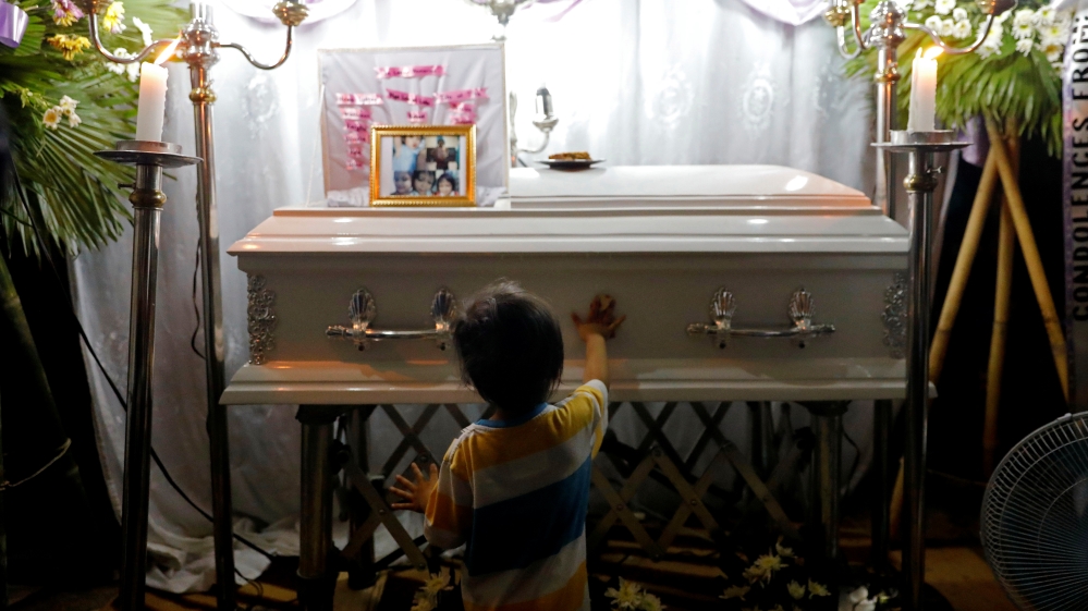 Brother of 3-year-old Ulpina wipes her casket during her wake in Rodriguez, Rizal province
