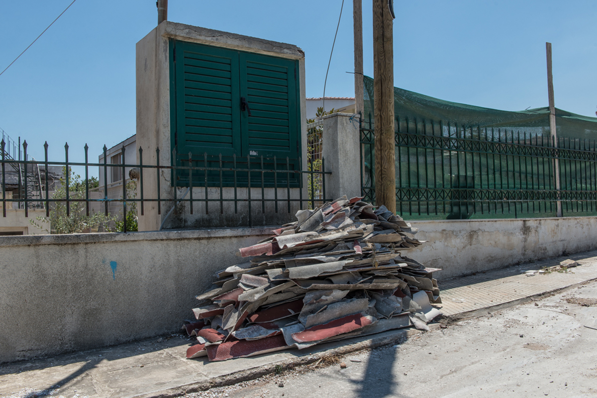 Built decades ago, many houses in Mati were constructed with asbestos, a carcinogenic substance that should not be touched with bare hands if burned. Residence and experts say the collection and remov