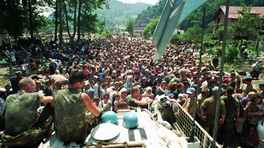FILE This July 13, 1995 file photo shows Dutch UN peacekeepers sitting on top of an APC as Muslim refugees from Srebrenica, eastern Bosnia, gather in the village of Potocari,