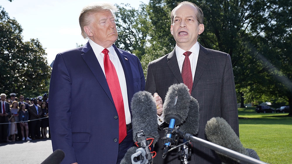 US President Donald Trump listens to Labor Secretary Alex Acosta who talks to reporters