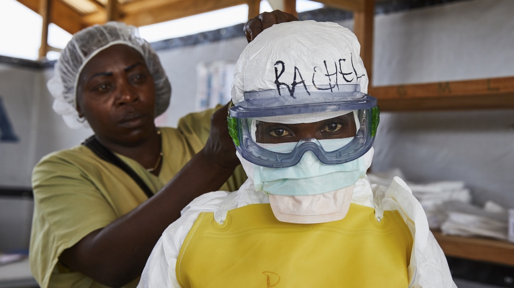 A health worker gets dressed in protective medical garments at an Ebola transit centre in Beni in North Kivu province